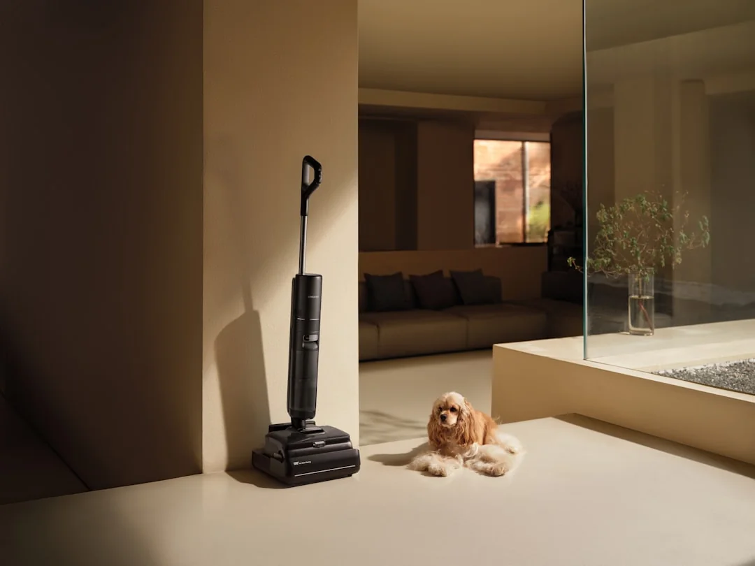 Asian woman cleaning a messy living room at home with a vacuum cleaner, creating a tidy space.